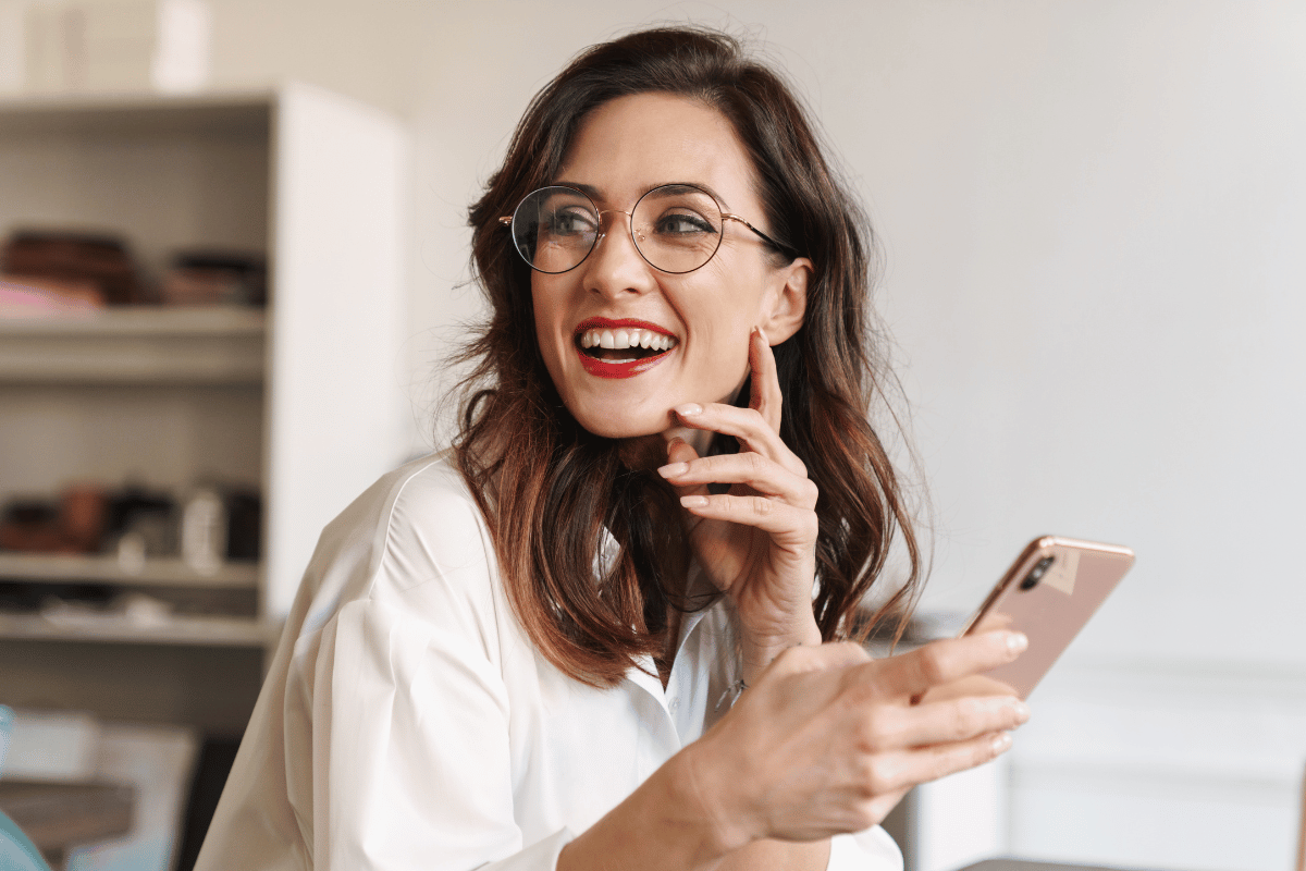 Smiling woman using her mobile phone