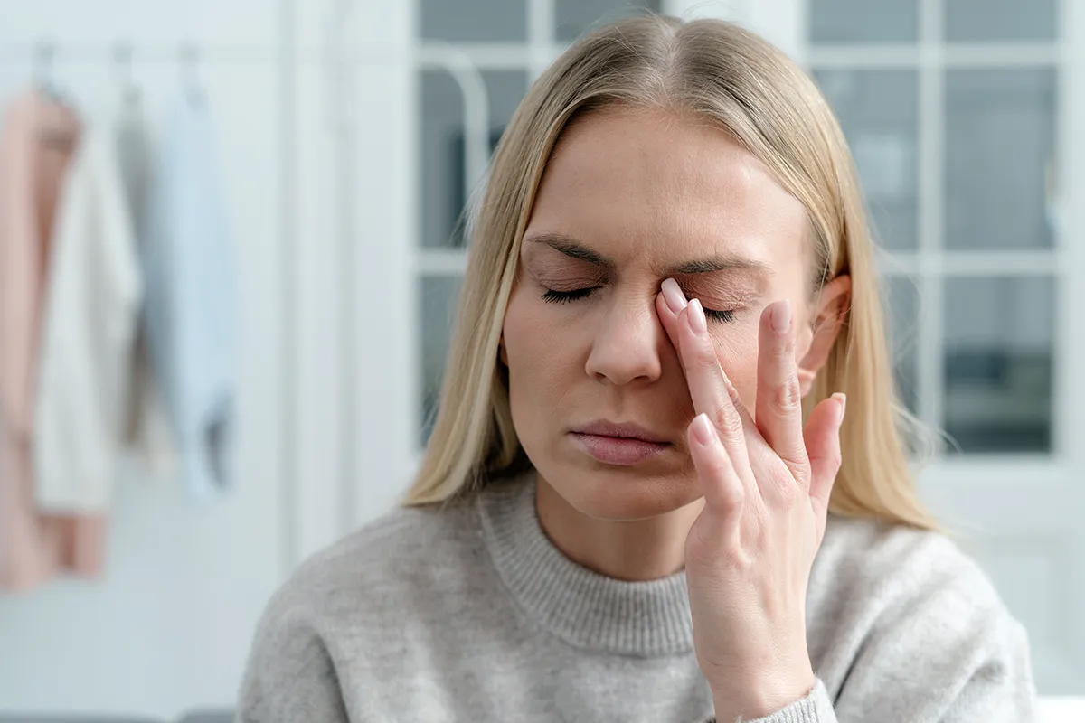 a woman rubbing her dry eyes