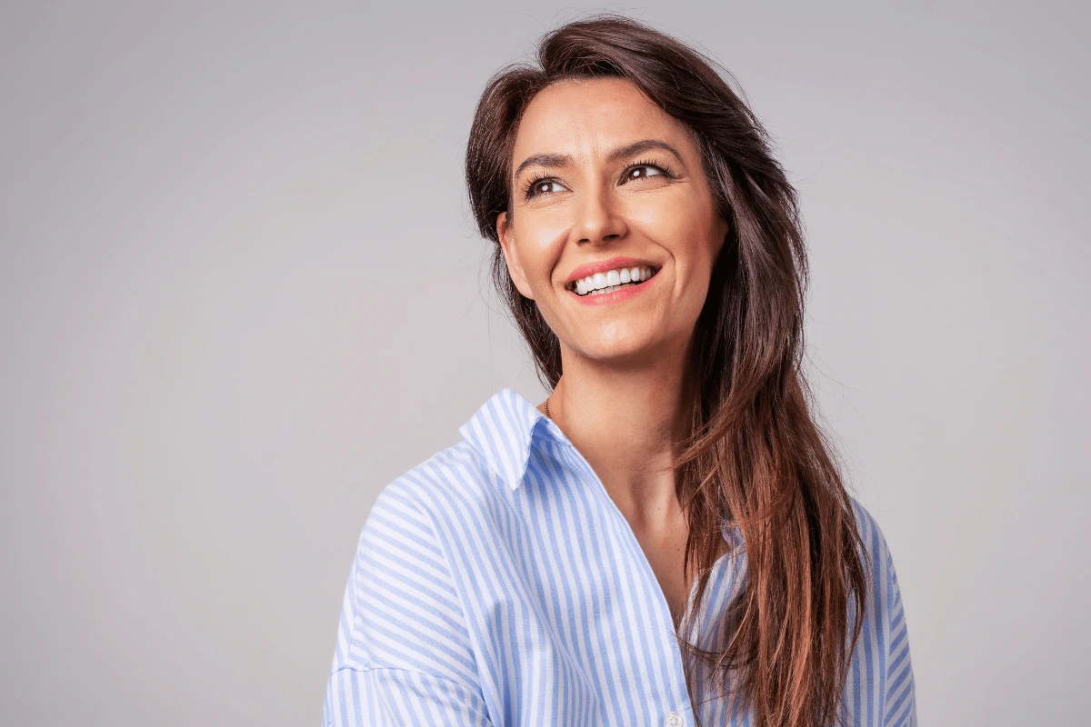 a woman smiling with a gray background